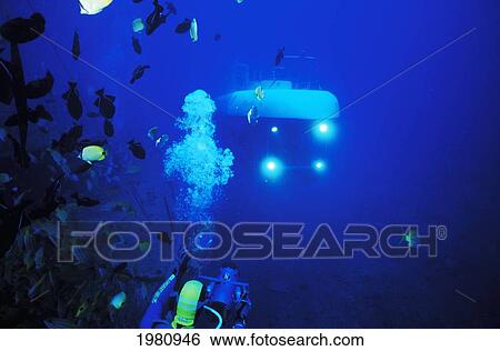Stock Photograph - Hawaii, Oahu, Waikiki, Headlights Of Atlantis Submarine On Atlantis Wreck, Diver In Foreground.. Fotosearch