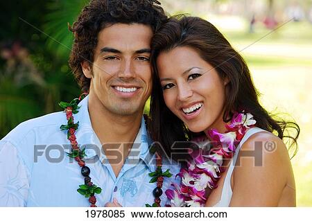 Stock Photography - Hawaii, Oahu, Waikiki, Kapiolani Park, Portrait Of A Gorgeous Couple Wearing Leis.. Fotosearch