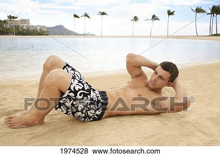 Hawaii, Oahu, Waikiki, Male Excercising On The Beach. View Large Photo Image Stock Photo - Hawaii, Oahu, Waikiki, Male Excercising On The Beach.. Fotosearch