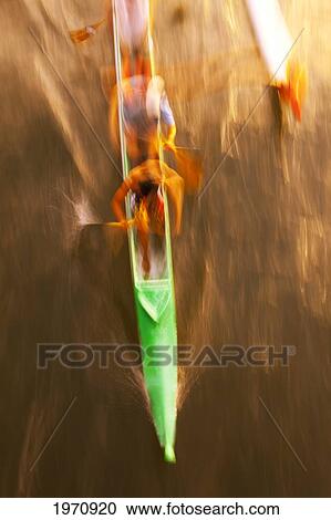 Stock Image - Hawaii, Oahu, Waikiki, Men Moving Quickly In An Outrigger Canoe On The Ala Wai.. Fotosearch