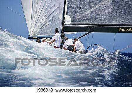 Stock Photo - Hawaii, Oahu, Waikiki Offshore Series 2005, Sailboat On Blue Ocean, Hull Of Boat Hidden By Swell.. Fotosearch
