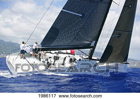 Stock Photo - Hawaii, Oahu, Waikiki Offshore Series 2005, Sailboat On Blue Ocean, Land In Background.. Fotosearch