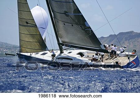 Stock Photo - Hawaii, Oahu, Waikiki Offshore Series 2005, Sailboat On Blue Ocean, Land In Background.. Fotosearch