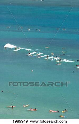 Stock Photo - Hawaii, Oahu, Waikiki, Surfers Riding A Wave Beautiful Turquoise Water [For Use Up To 13X20 Only]. Fotosearch