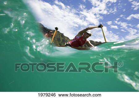 Stock Photograph - Hawaii, Oahu, Waimanalo, Female Outrigger Canoe Team Paddling Hard Through Blue-Green Ocean.. Fotosearch
