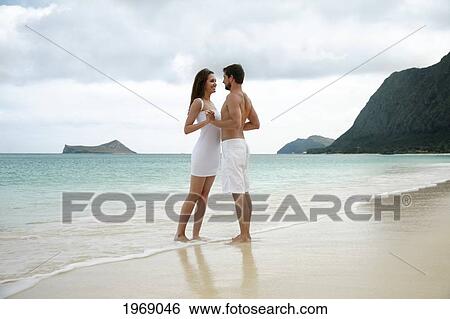 Hawaii, Oahu, Waimanalo, Young Happy Couple Holding Each Other On The Beach View Large Photo Image Stock Photograph - Hawaii, Oahu, Waimanalo, Young Happy Couple Holding Each Other On The Beach. Fotosearch