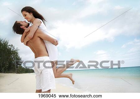 Stock Photography - Hawaii, Oahu, Waimanalo, Young Happy Couple Holding Each Other On The Beach. Fotosearch