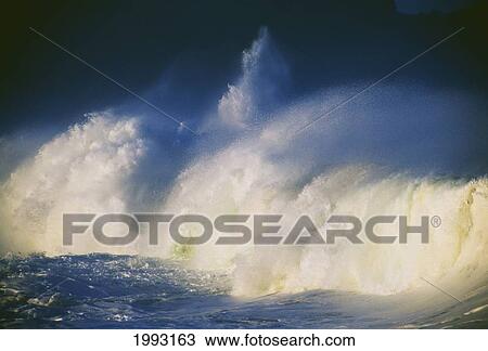 Stock Image - Hawaii, Oahu, Waimea Bay, Pounding Winter Surf, Big Waves Crashing Lit By Afternoon Sun.. Fotosearch