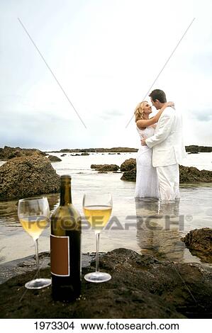 Hawaii, Oahu, Wedding Couple Kissing In The Tidepool With Wine Bottle And Two Glasses Left On A Rock In Foreground. View Large Photo Image Picture - Hawaii, Oahu, Wedding Couple Kissing In The Tidepool With Wine Bottle And Two Glasses Left On A Rock In Foreground.. Fotosearch