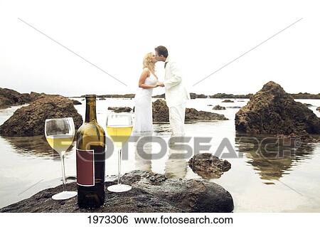 Hawaii, Oahu, Wedding Couple Kissing In The Tidepool With Wine Bottle And Two Glasses Left On A Rock In Foreground. View Large Photo Image Stock Photograph - Hawaii, Oahu, Wedding Couple Kissing In The Tidepool With Wine Bottle And Two Glasses Left On A Rock In Foreground.. Fotosearch