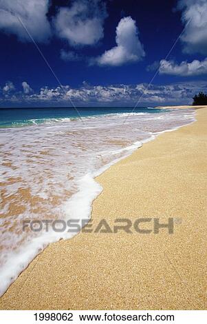 Stock Image - Hawaii, Oahu, White Wash Upon Beach Blue Skies With Clouds. Fotosearch