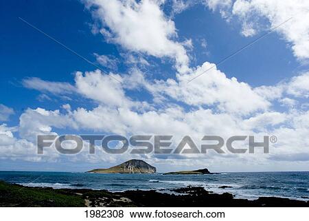 Stock Photo - Hawaii, Oahu, Windward, Waimanalo, Rabbit Island, calm blue ocean, cloudy blue sky. Fotosearch