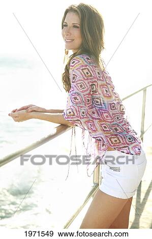 Stock Photo - Hawaii, Oahu, Woman Enjoying An Ocean View From Balcony Edge.. Fotosearch