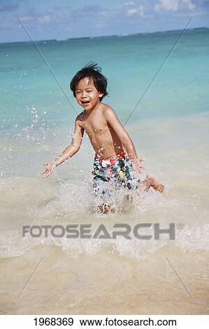 Stock Photo - Hawaii, Oahu, Young Boy Having Fun At The Beach In The Water.. Fotosearch