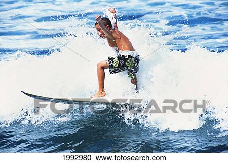 Stock Image - Hawaii, Oahu, Young Boy In Surfing With Arms Raised.. Fotosearch