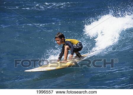 Hawaii, Oahu, Young Boy In Yellow Surfing On Yellow Surfboard. View Large Photo Image Stock Photo - Hawaii, Oahu, Young Boy In Yellow Surfing On Yellow Surfboard.. Fotosearch