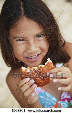 Hawaii, Oahu, Young Girl Enjoying A Malasada. View Large Photo Image Stock Image - Hawaii, Oahu, Young Girl Enjoying A Malasada.. Fotosearch