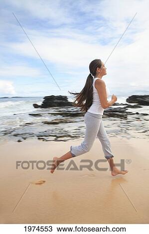 Stock Image - Hawaii, Oahu, Young Girl On The Beach Running In The Sand.. Fotosearch