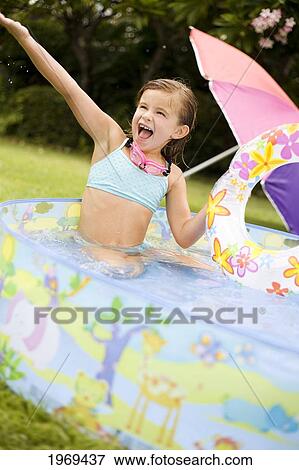 Hawaii, Oahu, Young Girl Playing In A Pool With An Innertube. View Large Photo Image Stock Photo - Hawaii, Oahu, Young Girl Playing In A Pool With An Innertube.. Fotosearch