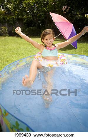 Stock Photo - Hawaii, Oahu, Young Girl Playing In A Pool With An Innertube.. Fotosearch
