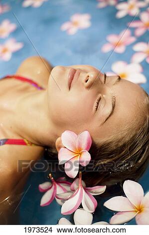 Hawaii, Oahu, Young Girl Resting In A Pool With Plumerias. View Large Photo Image Picture - Hawaii, Oahu, Young Girl Resting In A Pool With Plumerias.. Fotosearch