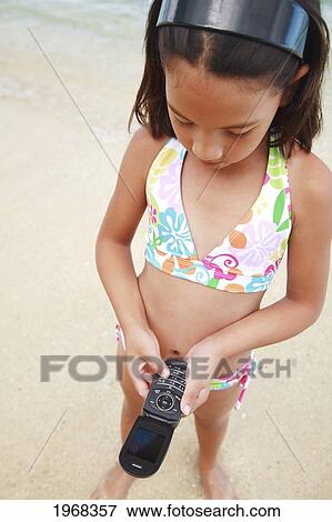 Hawaii, Oahu, Young Girl Talking On Her Cell Phone At The Beach. View Large Photo Image Stock Photo - Hawaii, Oahu, Young Girl Talking On Her Cell Phone At The Beach.. Fotosearch