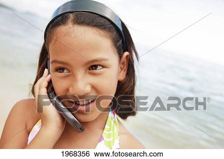 Hawaii, Oahu, Young Girl Talking On Her Cell Phone At The Beach. View Large Photo Image Stock Photograph - Hawaii, Oahu, Young Girl Talking On Her Cell Phone At The Beach.. Fotosearch