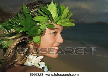 Stock Image - Hawaii, Oahu, Young Hula Dancer Wearing Maile Leaf Haku, Sunrise Light Along Windward Coast.. Fotosearch