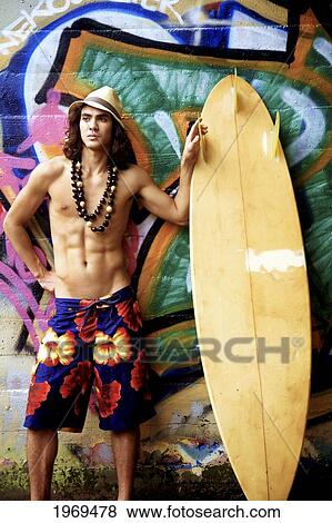Hawaii, Oahu, Young Male Posing Infront Of A Graphic Wall With Surfboard. View Large Photo Image Stock Photo - Hawaii, Oahu, Young Male Posing Infront Of A Graphic Wall With Surfboard.. Fotosearch