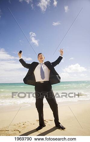 Stock Image - Hawaii, Oahu, Young Man At The Beach In Business Attire.. Fotosearch