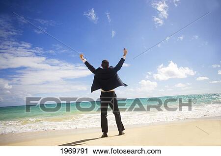 Stock Image - Hawaii, Oahu, Young Man At The Beach In Business Attire.. Fotosearch