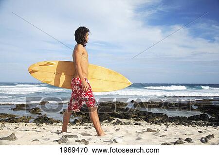 Stock Image - Hawaii, Oahu, Young Man At The Beach With Surfboard.. Fotosearch