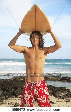 Stock Image - Hawaii, Oahu, Young Man At The Beach With Surfboard.. Fotosearch