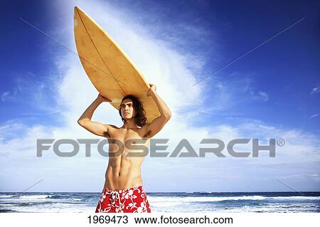 Stock Image - Hawaii, Oahu, Young Man At The Beach With Surfboard.. Fotosearch
