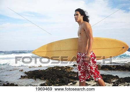 Stock Photo - Hawaii, Oahu, Young Man At The Beach With Surfboard.. Fotosearch