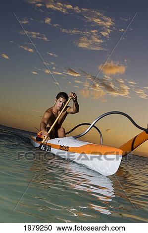 Hawaii, Oahu, Young Man Paddling A One Man Canoe At Sunset. View Large Photo Image Stock Image - Hawaii, Oahu, Young Man Paddling A One Man Canoe At Sunset.. Fotosearch
