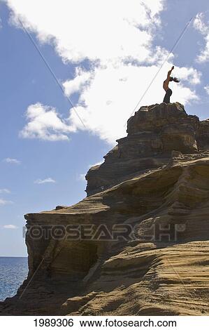 Hawaii, Oahu, Young Woman Doing Yoga On A Cliff Next To The Ocean. View Large Photo Image Stock Photograph - Hawaii, Oahu, Young Woman Doing Yoga On A Cliff Next To The Ocean.. Fotosearch