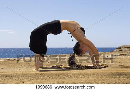 Hawaii, Oahu, Young Woman Doing Yoga Next To The Ocean. View Large Photo Image Stock Photograph - Hawaii, Oahu, Young Woman Doing Yoga Next To The Ocean.. Fotosearch