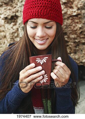 Stock Photo - Hawaii, Oahu, Young Woman Outside In Cozy Winter Weather Drinking Coffee.. Fotosearch