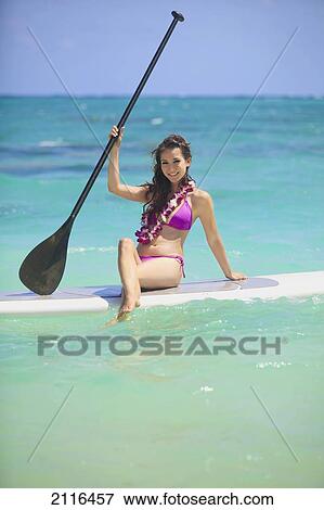 Hawaii, Oahu, Young woman posing on paddle board in ocean. View Large Photo Image Stock Photo - Hawaii, Oahu, Young woman posing on paddle board in ocean.. Fotosearch