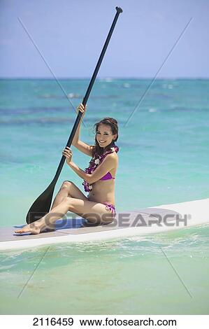 Hawaii, Oahu, Young woman posing on paddle board in ocean. View Large Photo Image Stock Photo - Hawaii, Oahu, Young woman posing on paddle board in ocean.. Fotosearch