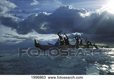 Hawaii, Ourigger Canoe Paddlers At Sunset, Rays Of Light Break Through Dramatic Sky View Large Photo Image Stock Image - Hawaii, Ourigger Canoe Paddlers At Sunset, Rays Of Light Break Through Dramatic Sky. Fotosearch