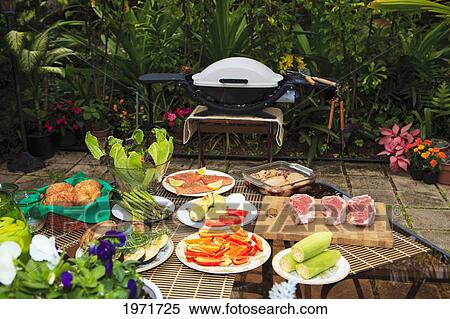 Stock Photography - Hawaii, Outdoor Barbecue With Steaks, Salmon, Chicken And Side Dishes.. Fotosearch