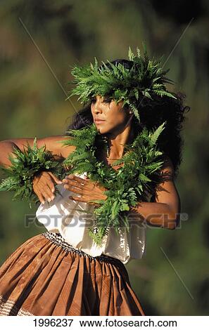 Stock Photo - Hawaii, Outdoor Front Angle Of Woman Dancing Hula, Wearing Fern Haku, Lei And Kupe'e Blurry Background. Fotosearch
