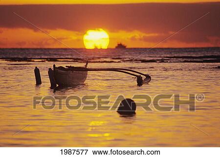 Stock Photo - Hawaii, Outigger Canoe Silhouetted On Ocean At Sunset, Orange Reflections On Water And Sun On Horizon.. Fotosearch