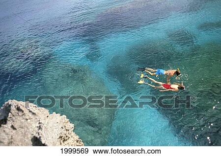 Hawaii, Overview Of Couple Snorkeling Over Coral Ocean Waters View Large Photo Image Stock Photo - Hawaii, Overview Of Couple Snorkeling Over Coral Ocean Waters. Fotosearch