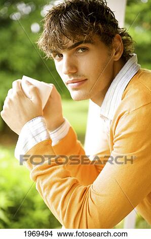 Picture - Hawaii, Portrait Of A European Male Model In Orange Sweater Drinking Coffee.. Fotosearch