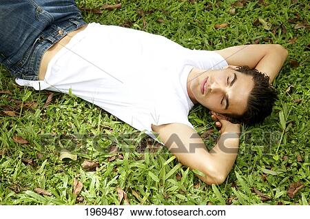Stock Photo - Hawaii, Portrait Of A European Male Model Laying On Grass.. Fotosearch