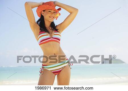 Stock Image - Hawaii, Portrait Of Beautiful Sophisticated Girl At The Beach Wearing Striped Bikini And Straw Hat.. Fotosearch