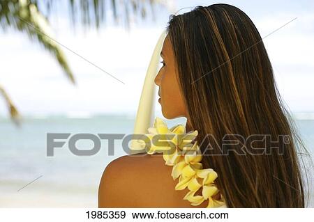 Stock Photo - Hawaii, Portrait Shot Of A Teenage Surfer Girl Wearing A Yellow Plumeria Lei, Holding A Surfboard.. Fotosearch